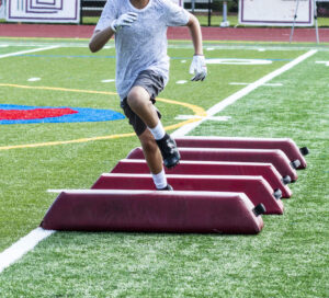 football player practicing on artificial grass