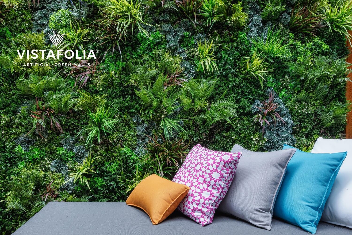 Artificial living wall with couch with decorative pillows