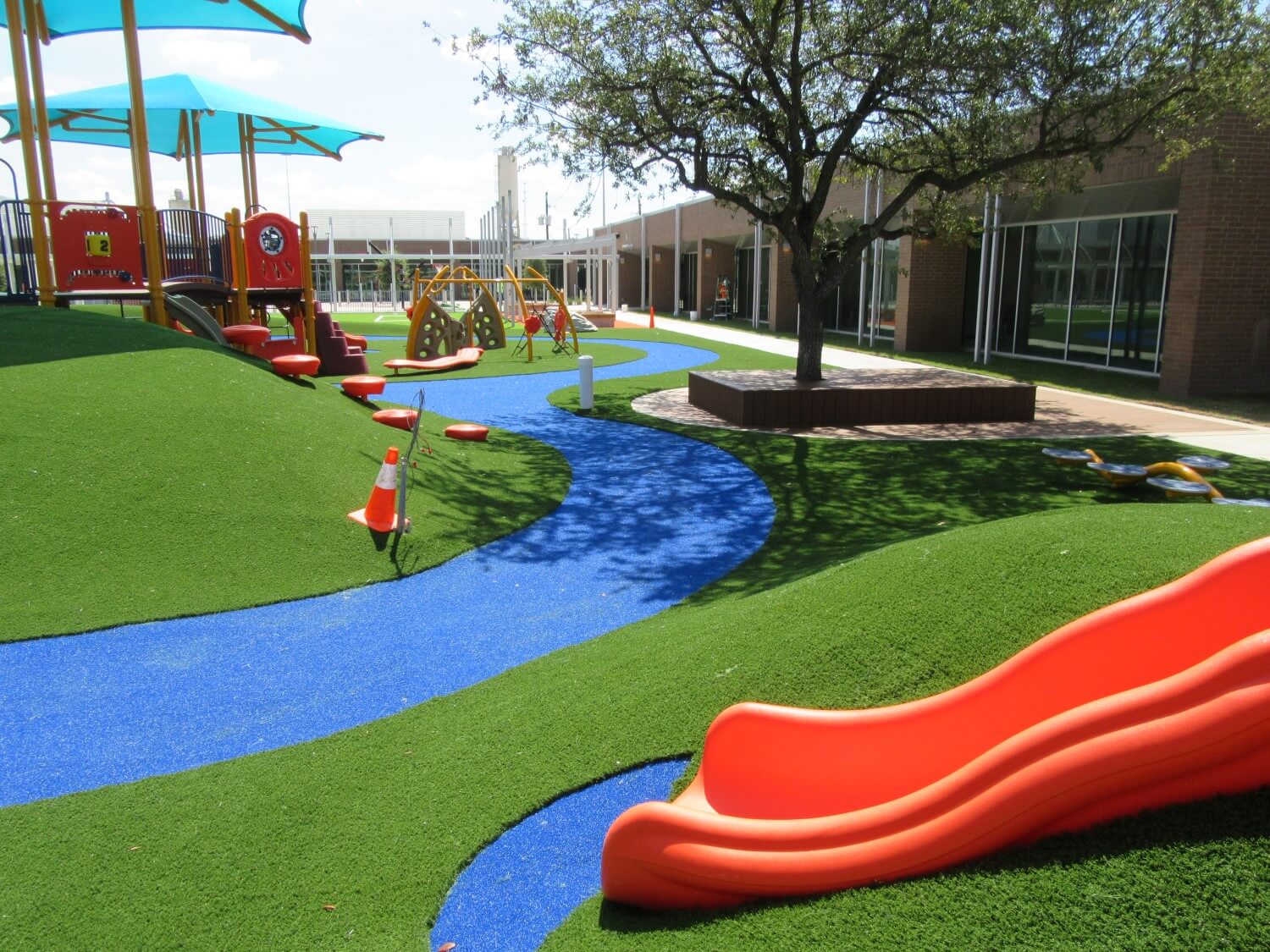 Artificial playground grass with orange slide