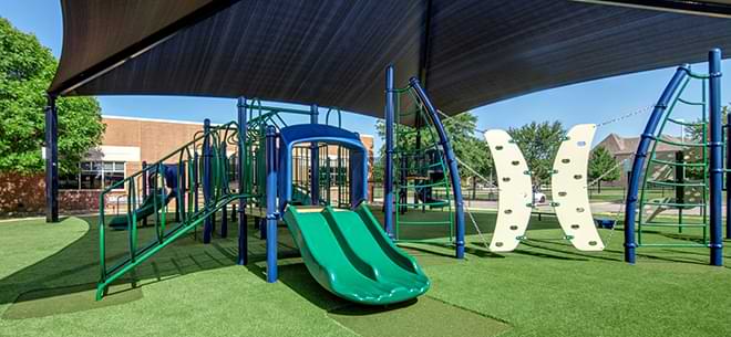 Green slide installed on artificial playground grass from SYNLawn